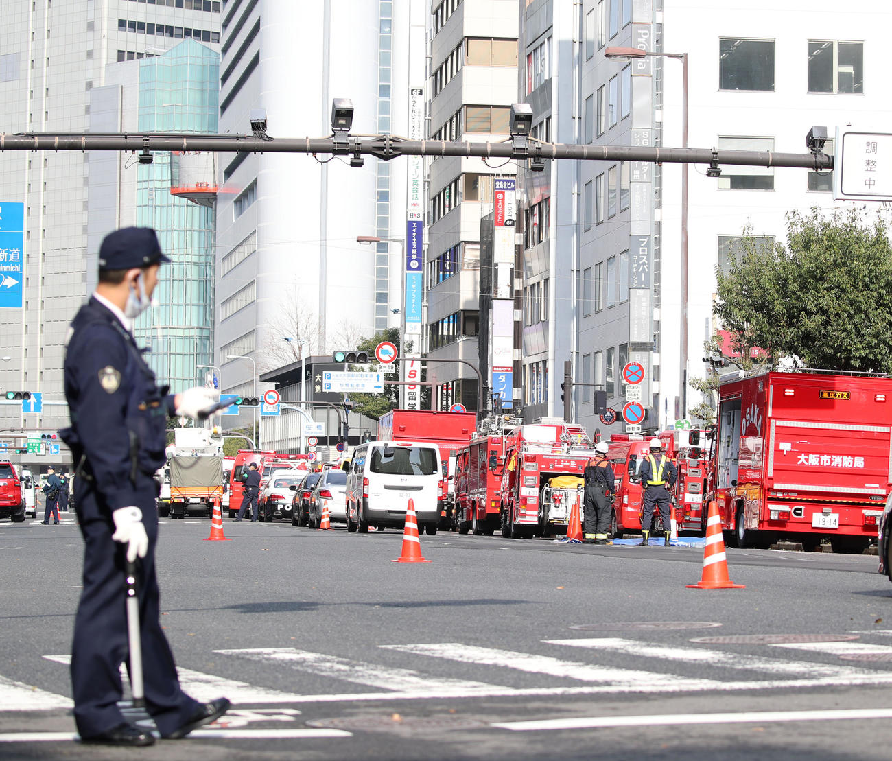 警察官が道路を規制し多くの消防車が並ぶ火災現場前（撮影・加藤哉）