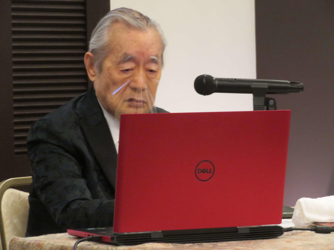 新たな図形、標識として「CHALLENGE」を発表しつつ、ノートパソコンの画面に厳しい視線を投げ掛けるドクター・中松氏（撮影・村上幸将）