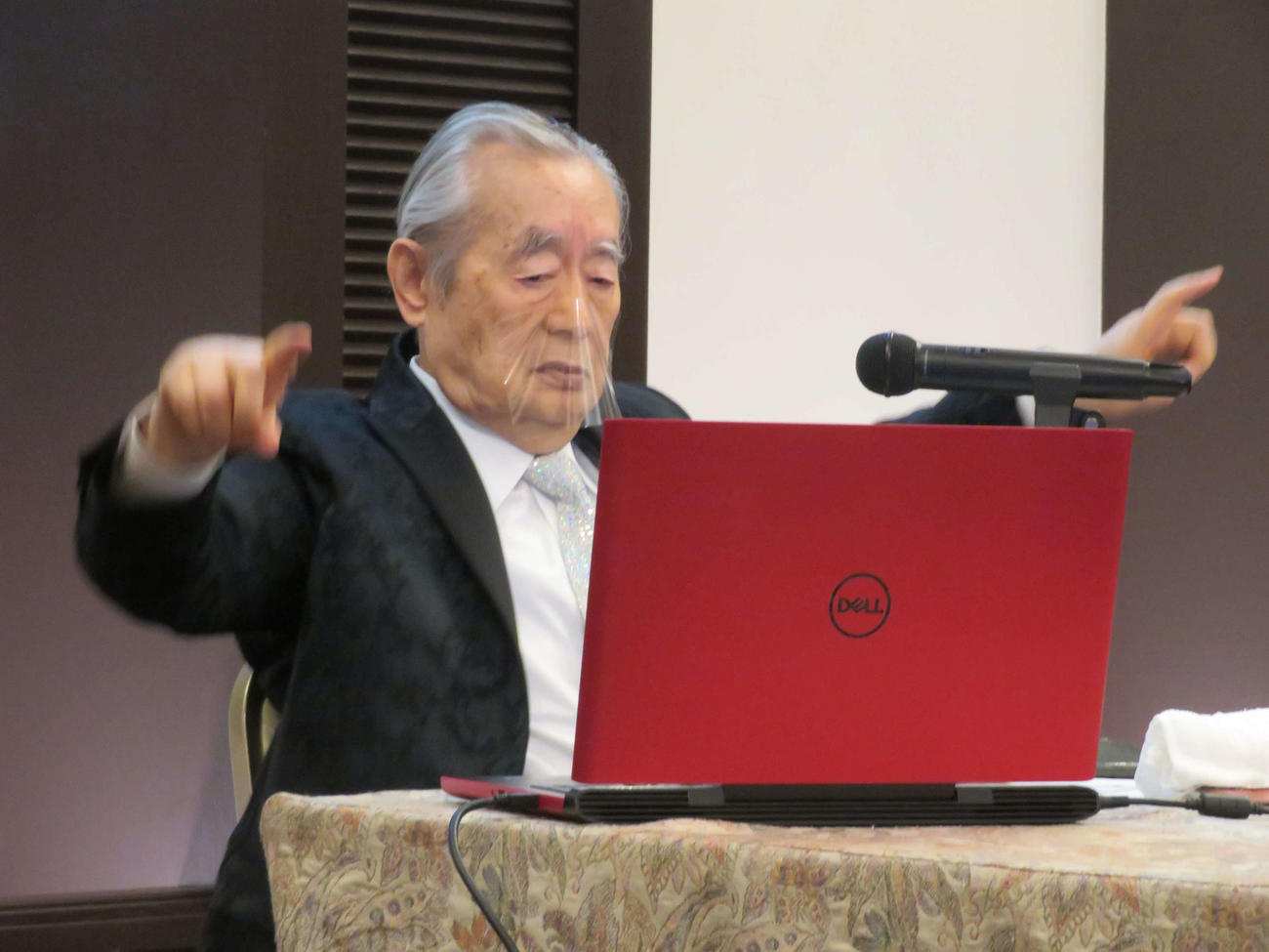 新たな図形、標識として発表した「CHALLENGE」を全身を使って表現するドクター・中松氏（撮影・村上幸将）