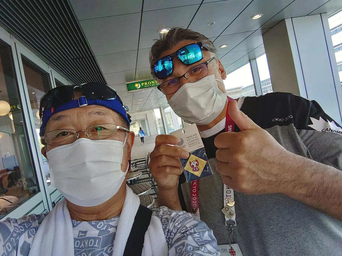 海外メディアの男性（右）とピントレードを楽しむ玉井政道さん（本人提供）