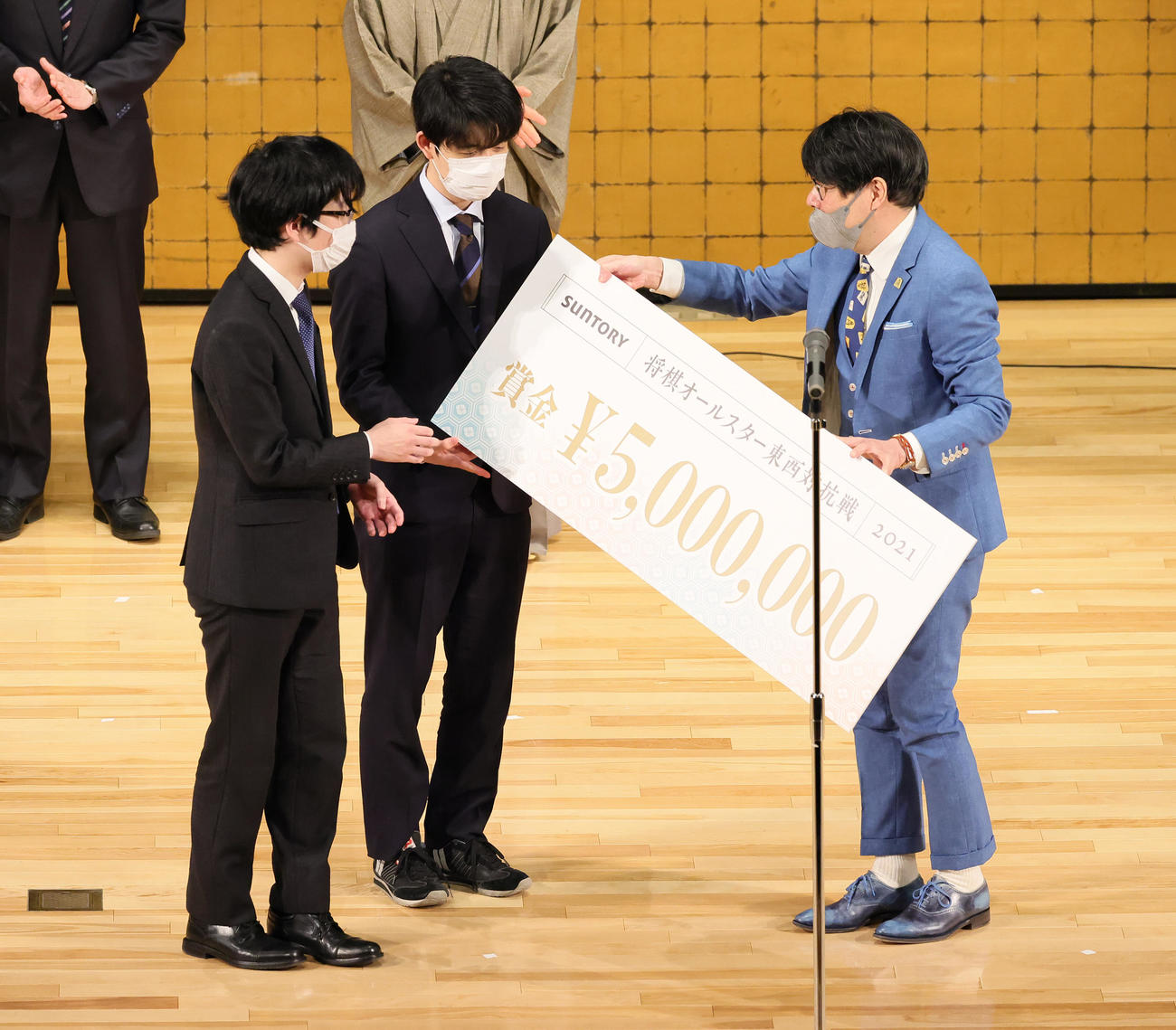 賞金500万円を受け取る藤井聡太竜王（中央）と豊島将之九段（左）（撮影・足立雅史）