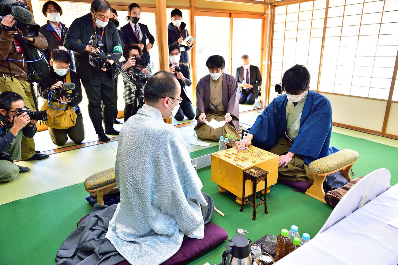 開封された封じ手を指す藤井聡太竜王（右、日本将棋連盟提供）