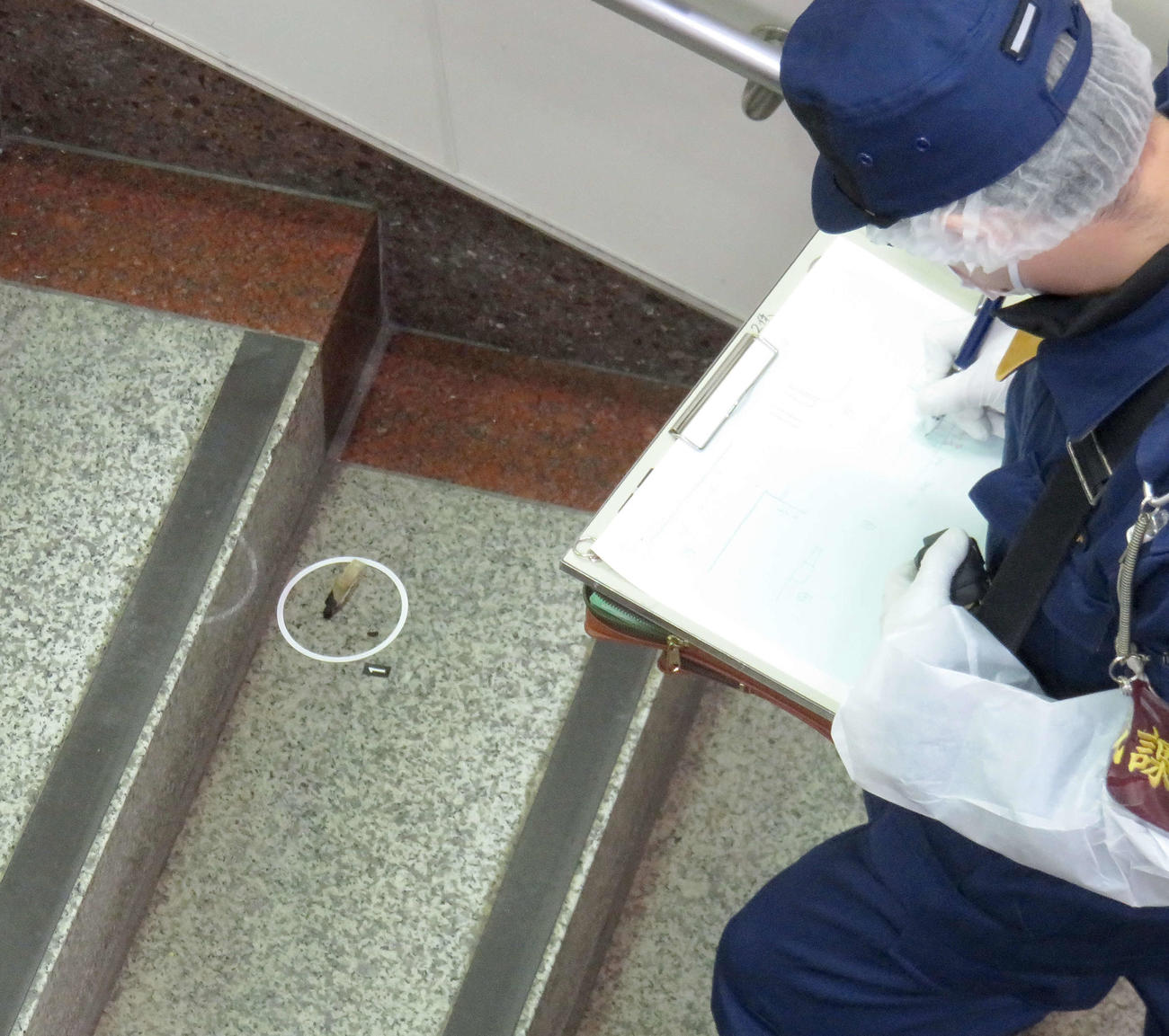 15日、着火剤のようなものがまかれた東京メトロ南北線東大前駅で燃え跡とみられるものをチェックする捜査官