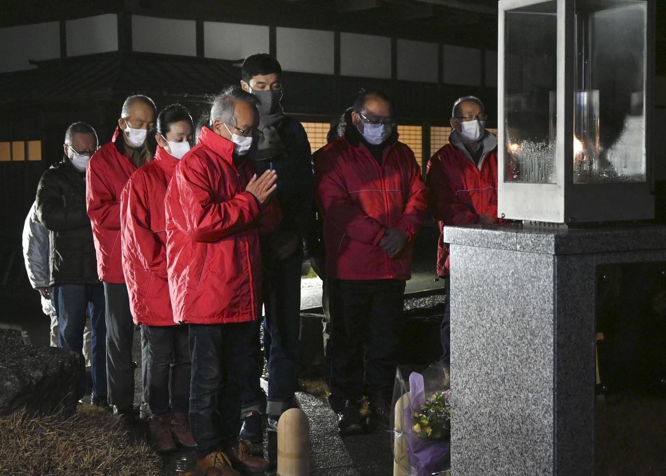 神戸市から分灯された「希望の灯り」前で、阪神大震災が発生した時刻に合わせ黙とうする人たち（共同）