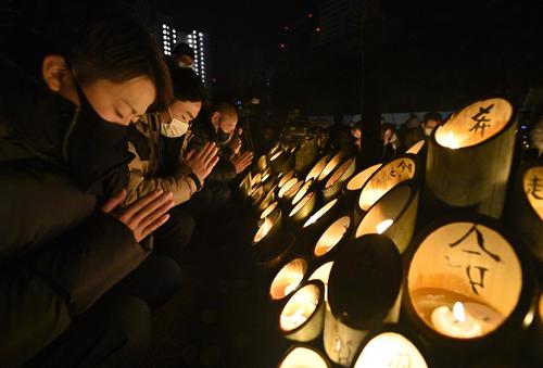 阪神大震災から27年となり、地震の発生時刻に合わせて黙とうする人たち（共同）