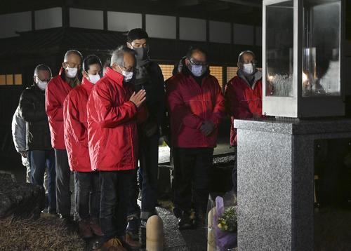 神戸市から分灯された「希望の灯り」前で、阪神大震災が発生した時刻に合わせ黙とうする人たち（共同）