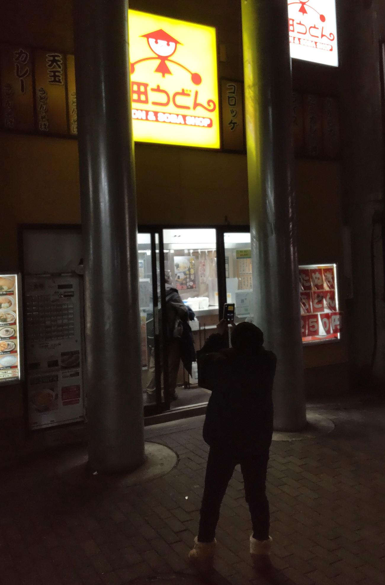閉店直後、通行人が携帯電話で山田うどんの看板を撮影していた（撮影・寺沢卓）