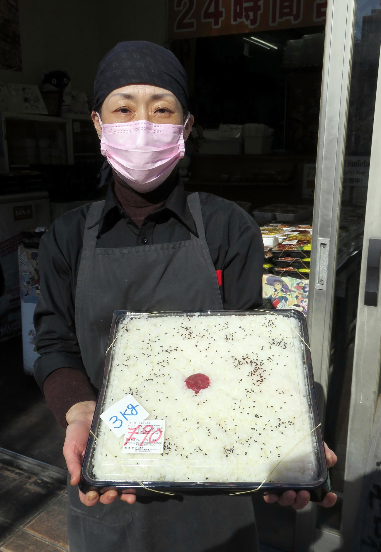 重さ3キロの日の丸弁当“ドカベン弁当”を抱える「キッチンDIVE」従業員（撮影・鎌田直秀）