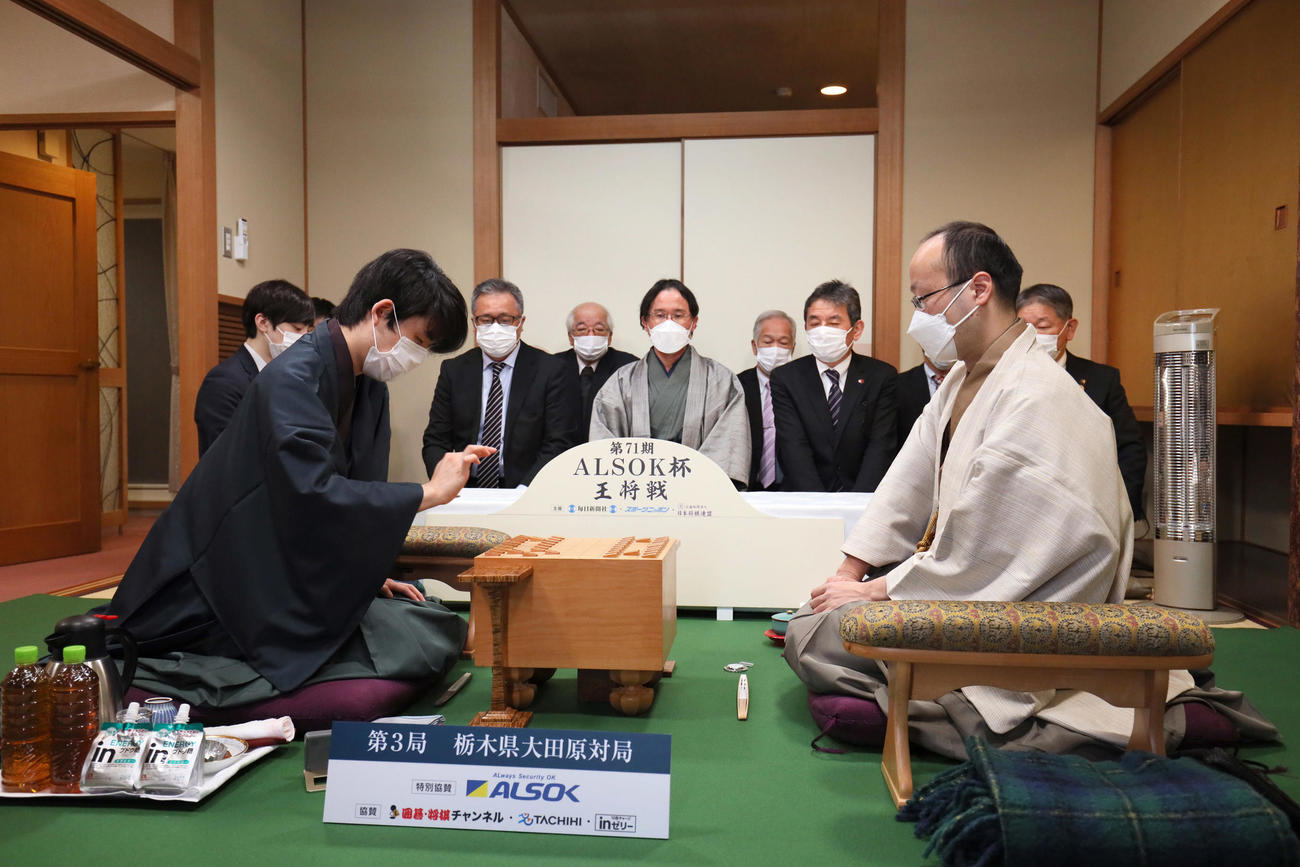 王将戦7番勝負第3局で初手を指す挑戦者の藤井竜王（左）。右は渡辺王将（2022年1月29日・代表撮影）