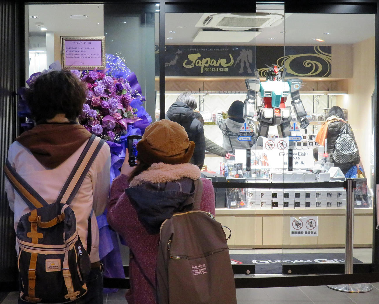 ガンダムカフェ秋葉原店に送られた花を撮影するファンたち（撮影・鎌田直秀）