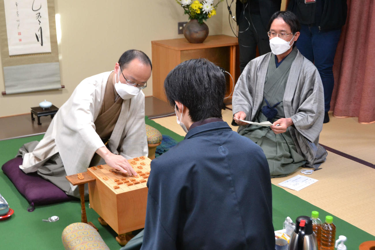 渡辺明王将（左）が開封された封じ手を指して王将戦7番勝負第3局は再開された右は立会人の深浦康市九段（日本将棋連盟提供）