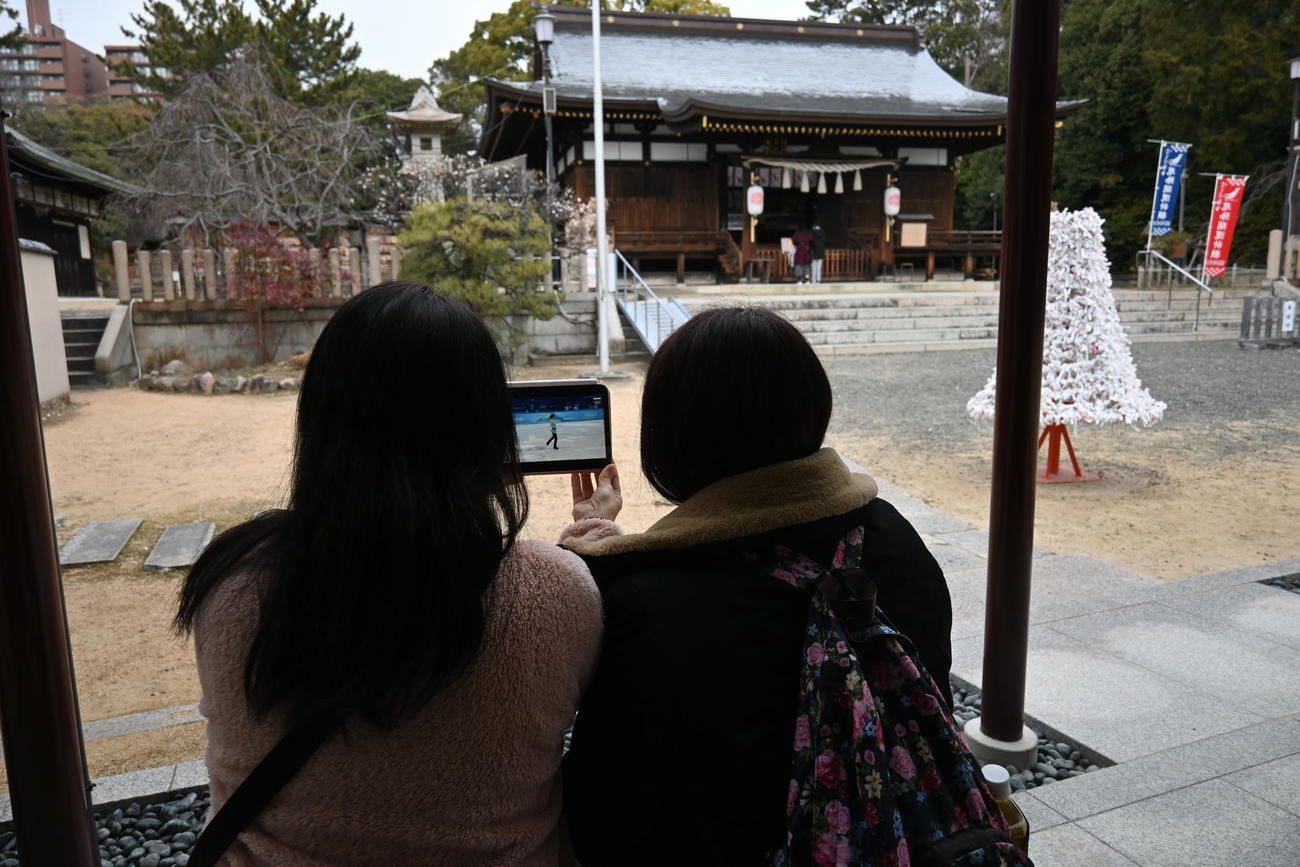 ファンの「聖地」弓弦羽神社で羽生結弦のフリーをタブレットで観戦するファン（撮影・松浦隆司）