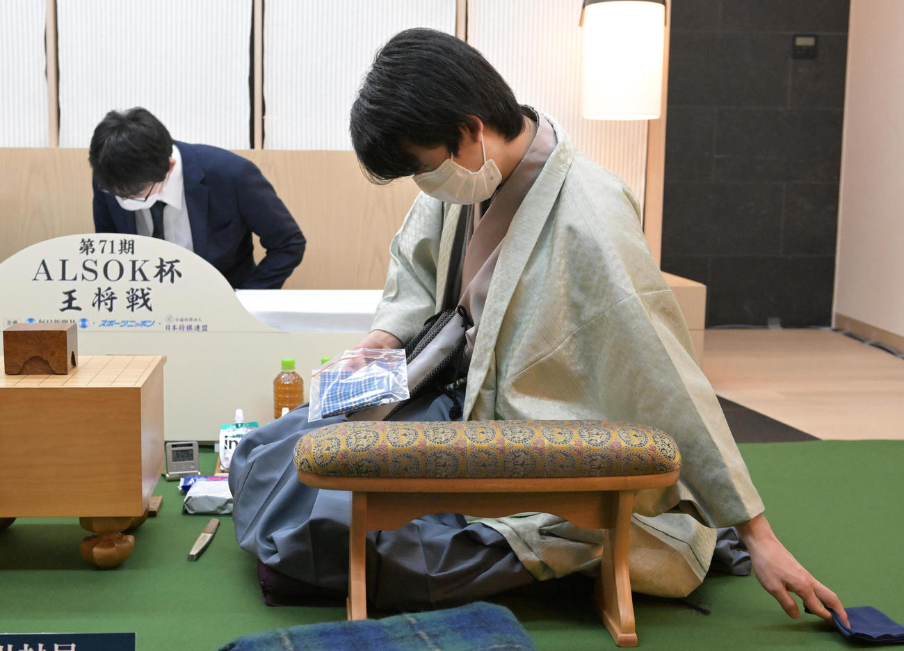 第71期ALSOK杯王将戦七番勝負第4局第1日を終え、ハンカチを片付ける藤井聡太竜王（代表撮影）