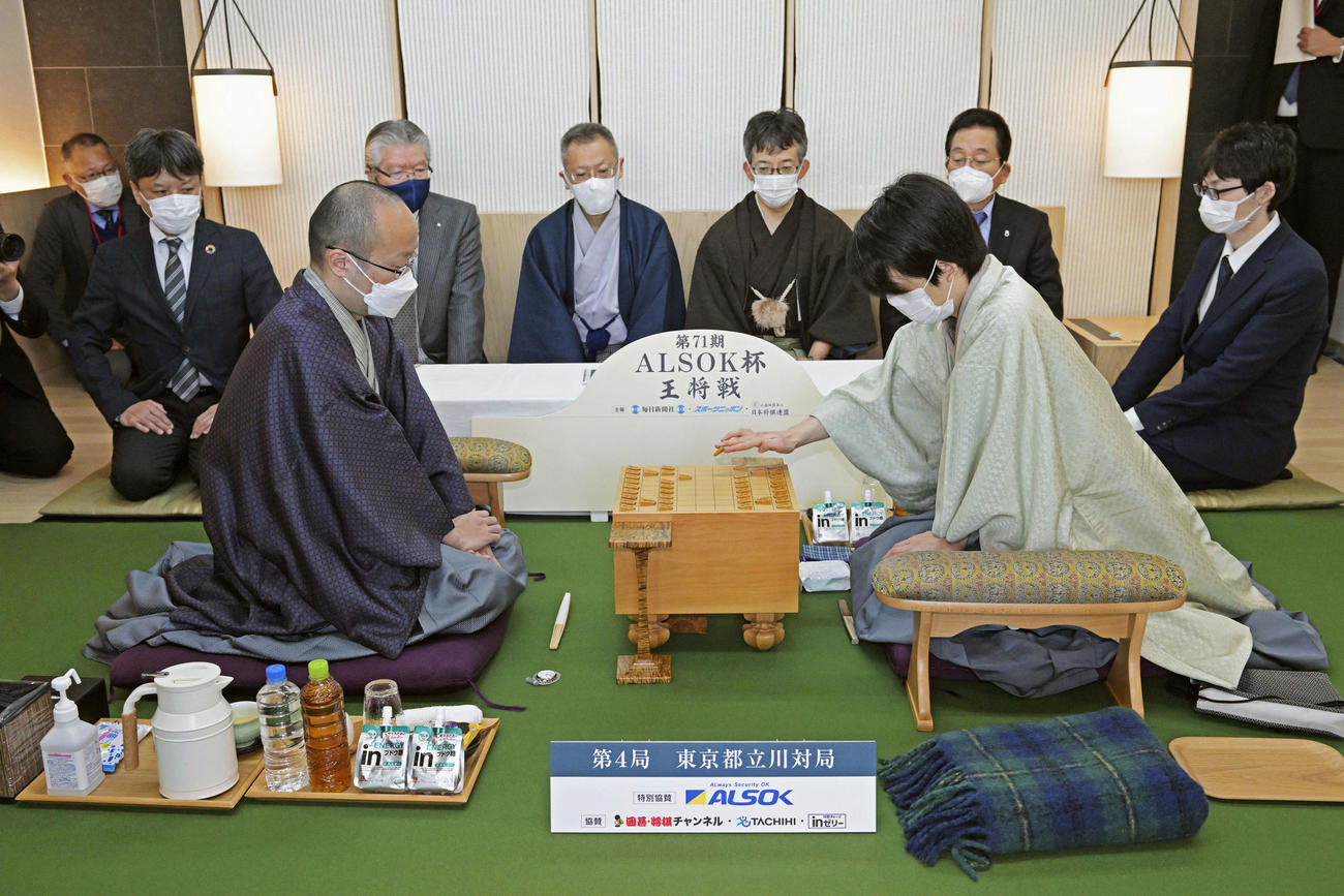 第71期ALSOK杯王将戦七番勝負第4局で2手目を指す挑戦者の藤井聡太竜王（右）。左は渡辺明王将（代表撮影）