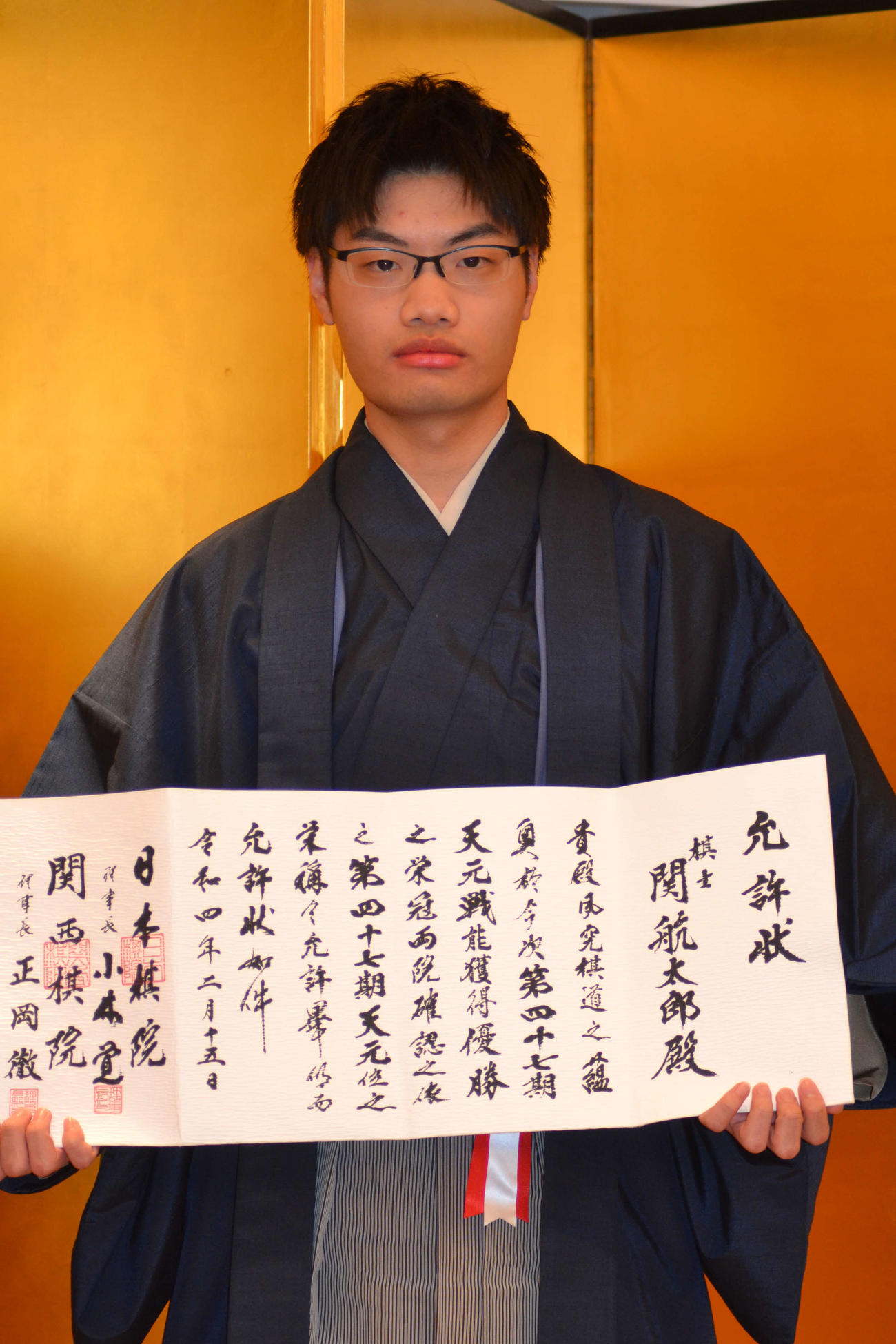 就位式で允許（いんきょ）状を手にする関航太郎天元