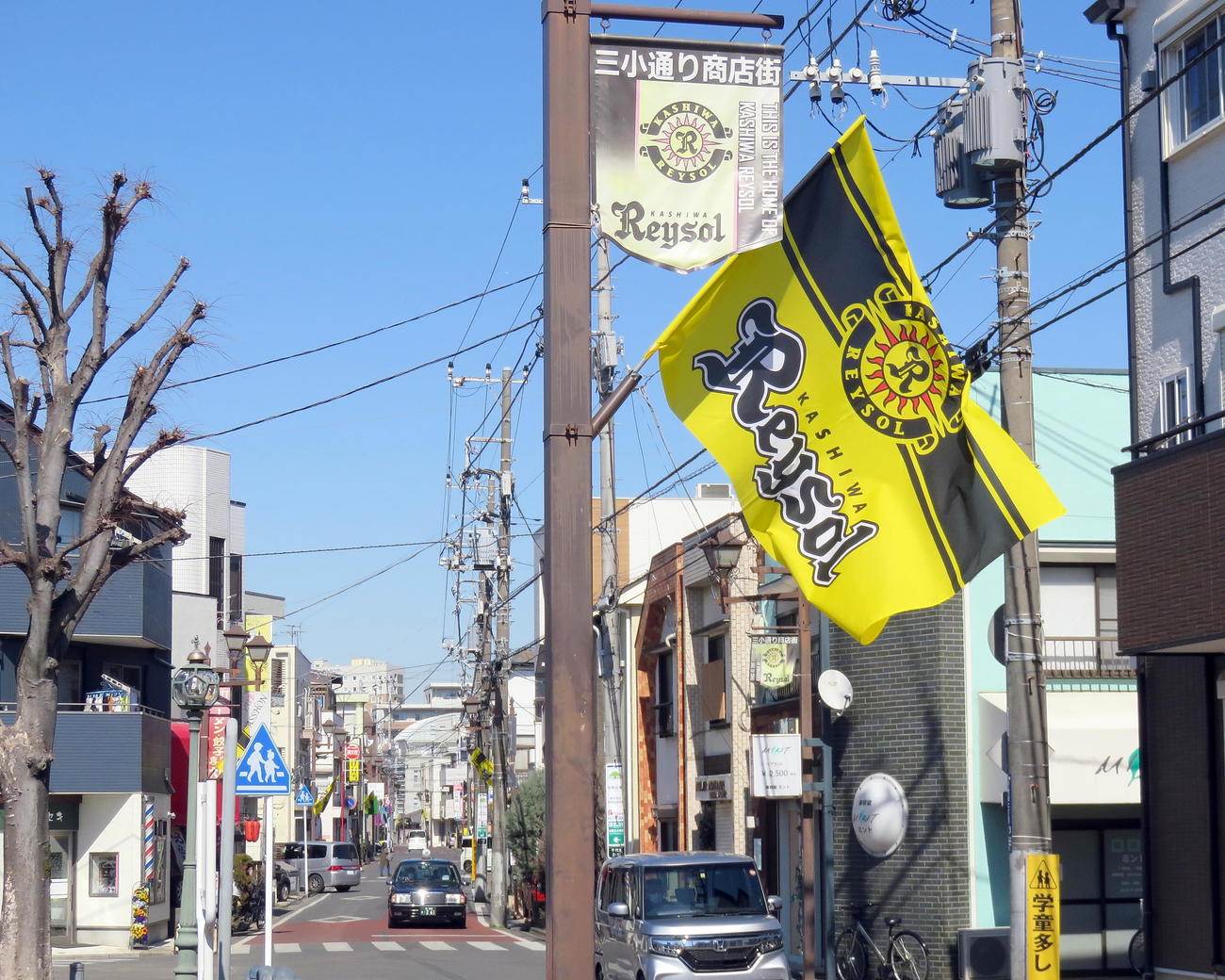 26日、新しいフラッグが風になびく三小通り商店街（撮影・鎌田直秀）