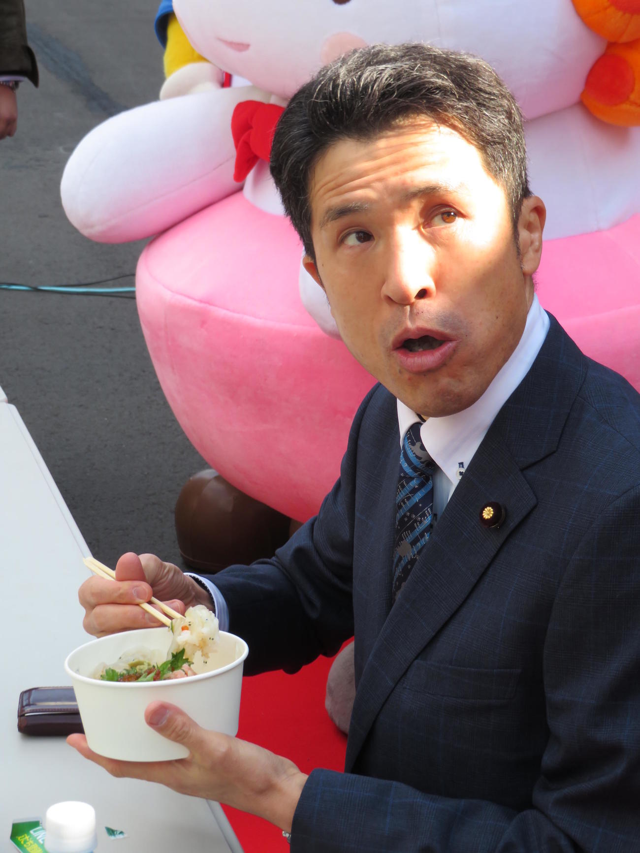 「これ朝飯なんです。おいしいですね」と試食に舌鼓を打つ新妻秀規復興庁副大臣（撮影・寺沢卓）