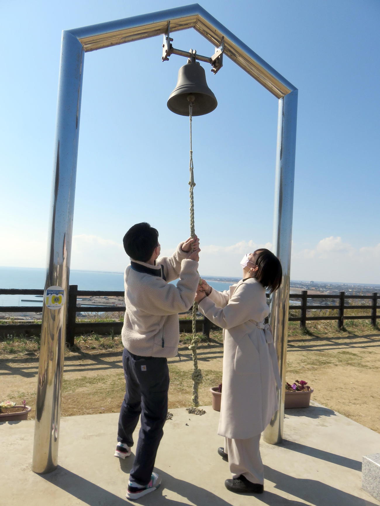 旭市を眺望出来る飯岡刑部岬展望館に隣接する「希望の鐘」を鳴らすカップル（撮影・鎌田直秀）