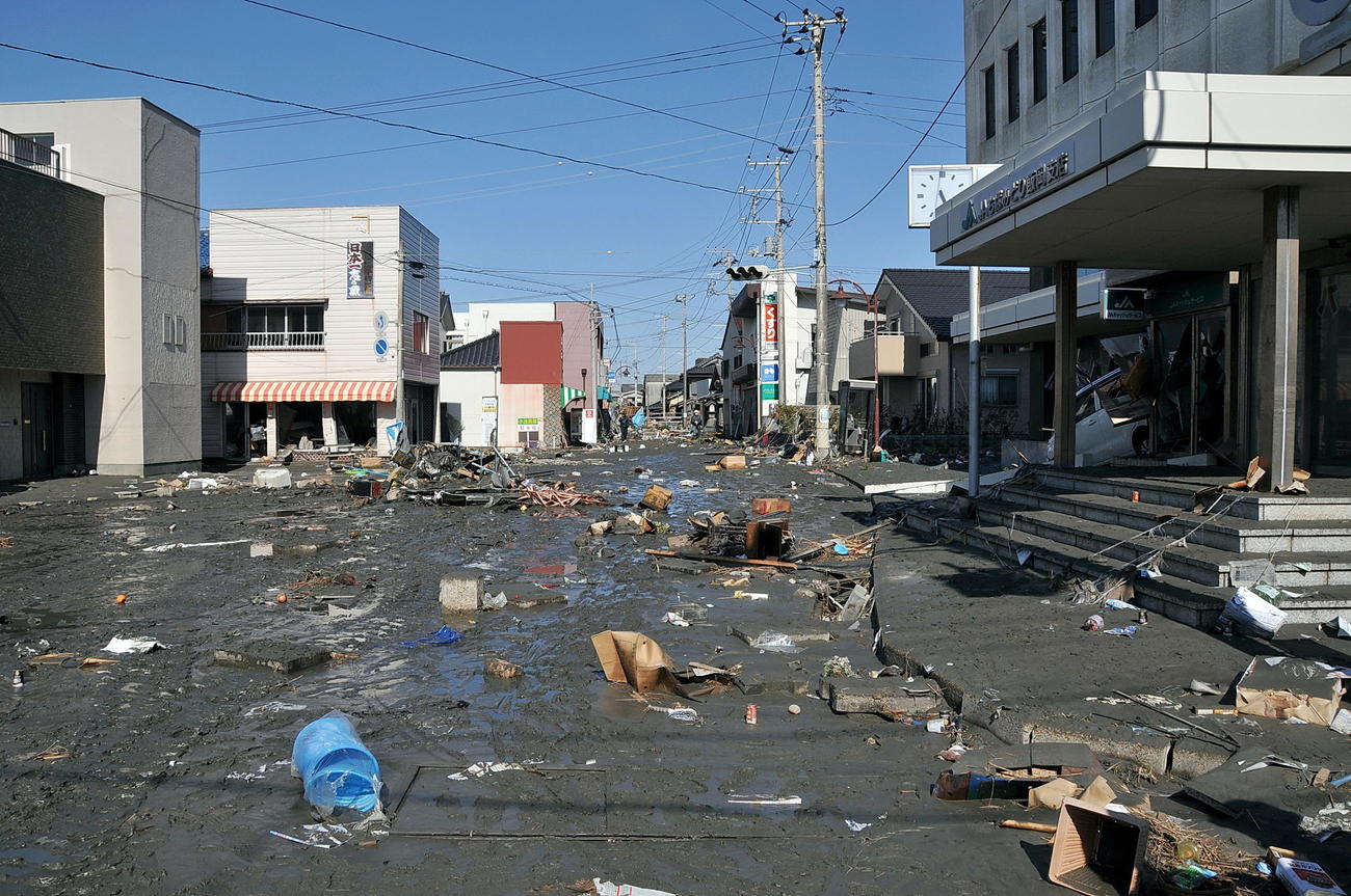 2011年3月12日、がれきや泥で埋もれた千葉県旭市のJAちばみどり飯岡支店前（旭市提供）