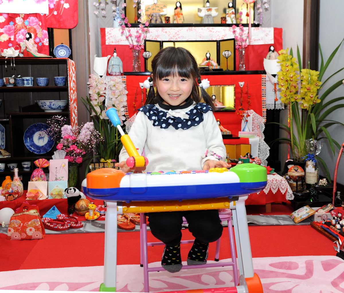 子ども用のピアノを笑顔で演奏する小松倫子ちゃん＝2013年3月4日