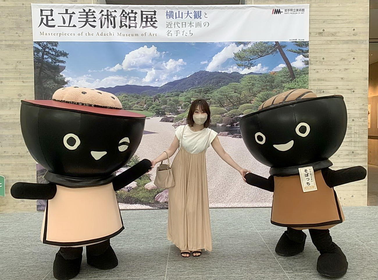 岩手県観光協会マスコットキャラクター「わんこきょうだい」の「こくっち」（左）、「そばっち」と手をつなぐ柳瀬夏美さん