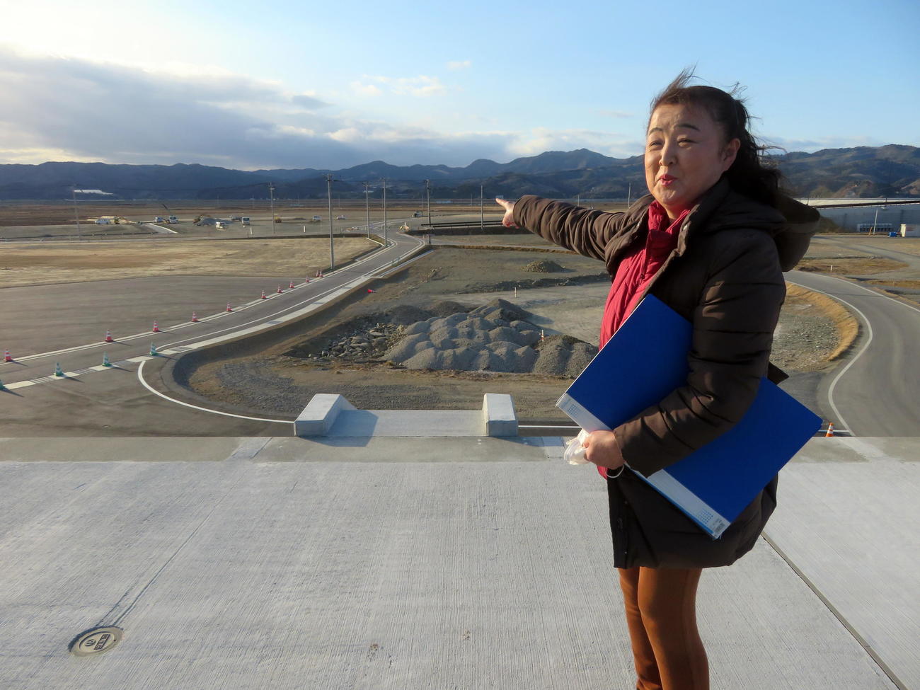 津波で更地になってしまった自宅があった場所を指さす三條すみゑさん（撮影・三須一紀）