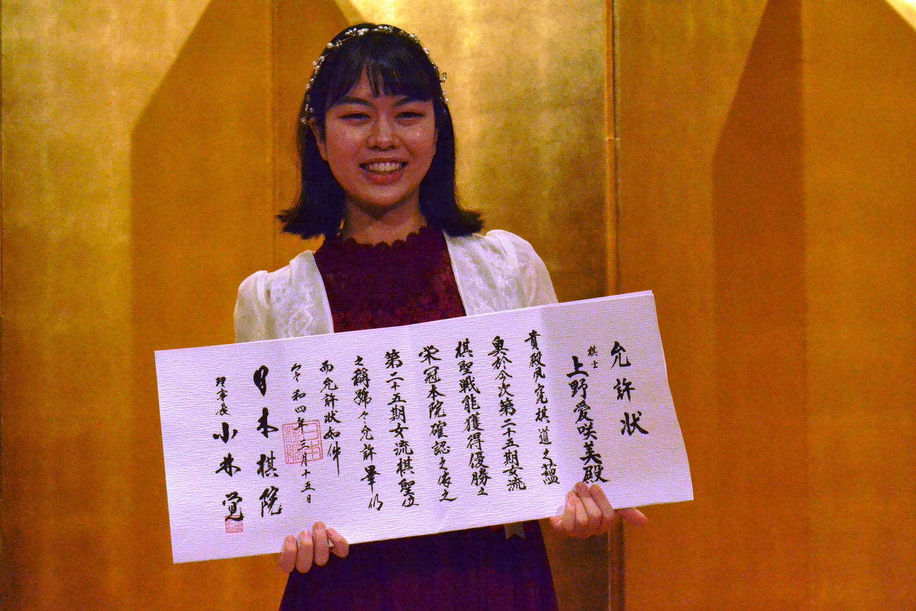 允許（いんきょ）状を揺らしながら笑顔で撮影に応じる上野愛咲美女流棋聖