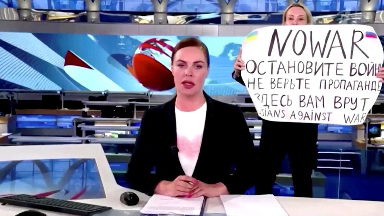 ロシア「第1チャンネル」のニュース生放送中に女性社員がキャスターの背後で「NO WAR」「戦争を止めろ。プロパガンダを信じるな」と書かれた紙を掲げた（ロイター）