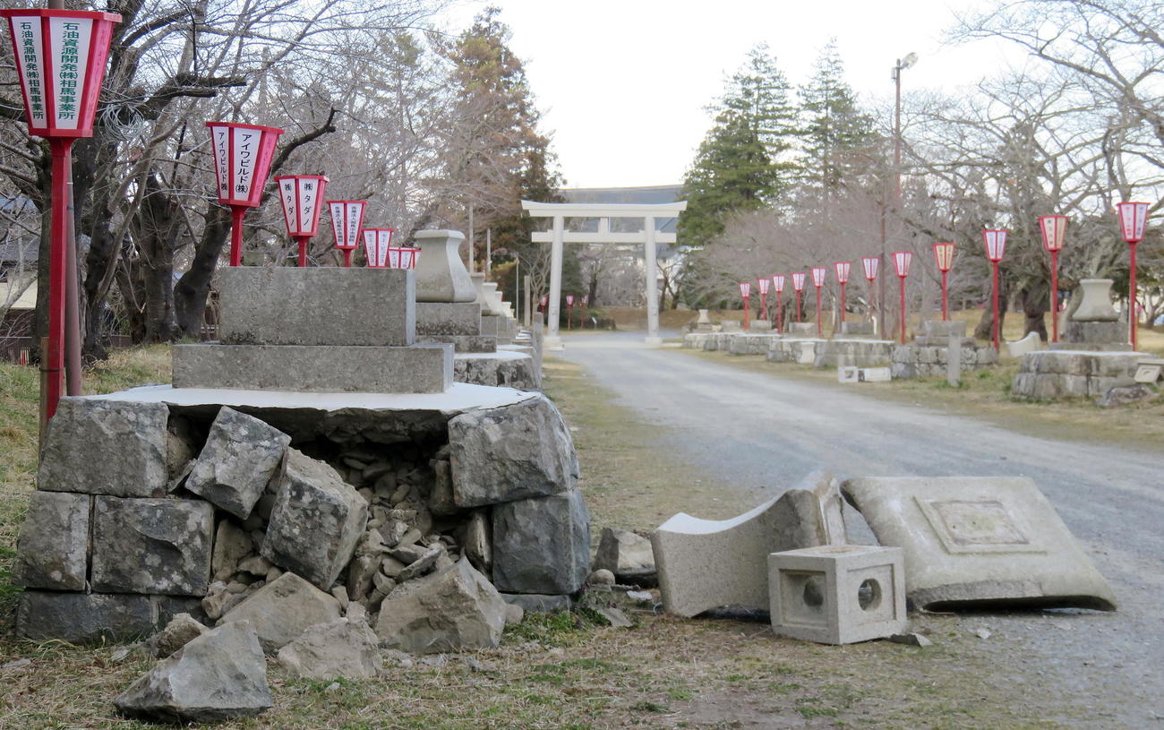 数多くの石灯籠が壊れた相馬中村神社の参道。奥は昨年12月に新設されたステンレス製の大鳥居（撮影・鎌田直秀）