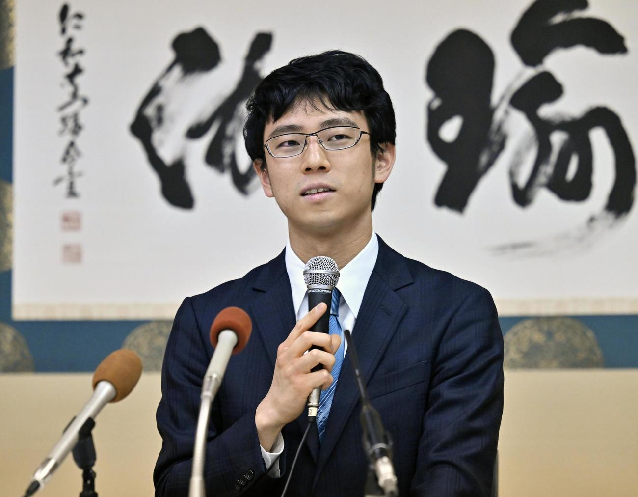 記者会見で喜びを語る一力遼新棋聖（共同）