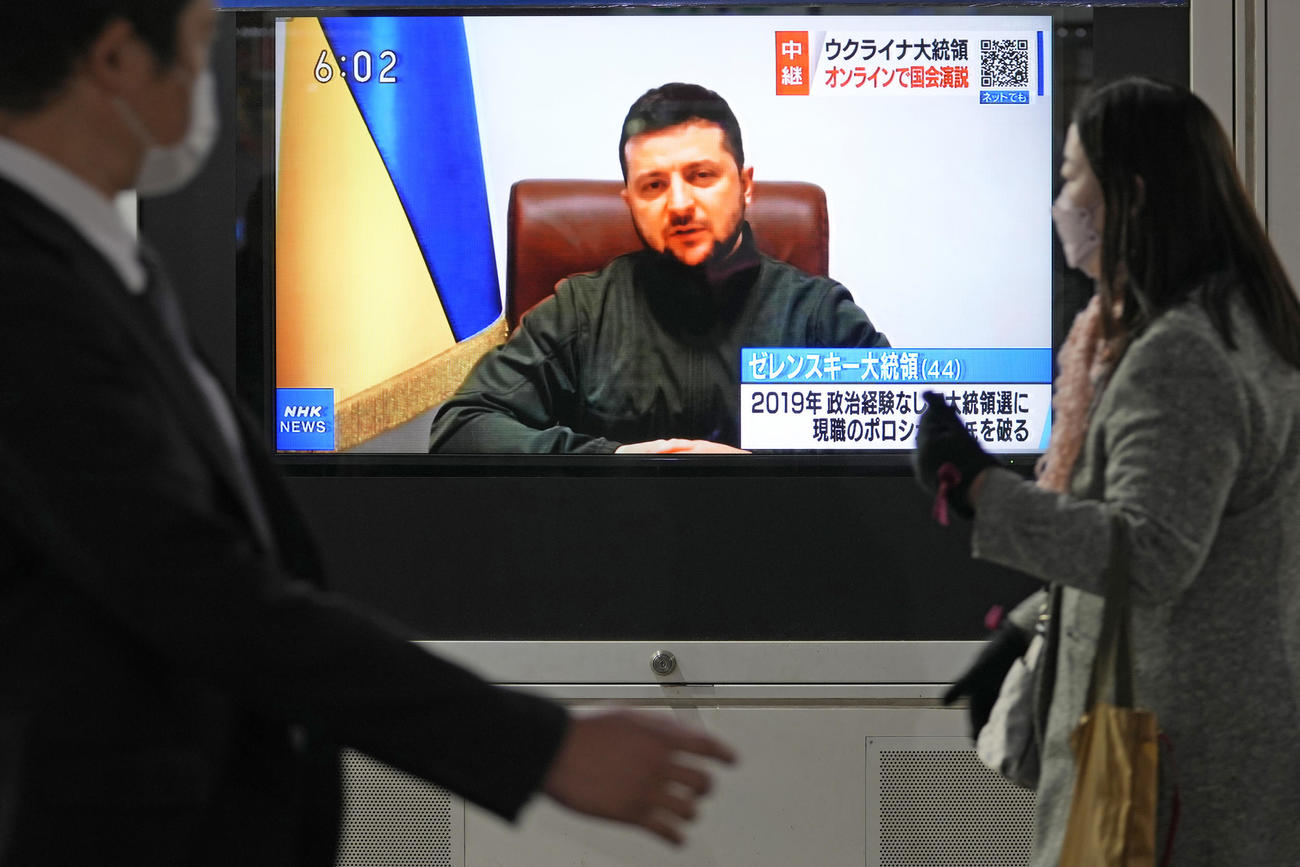 日本の国会議員に向け、オンラインで演説するウクライナのゼレンスキー大統領を映す街角（AP）