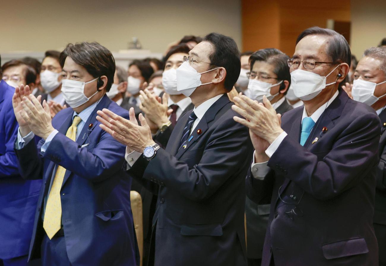 オンライン演説を終えたウクライナのゼレンスキー大統領に向け、拍手する岸田首相（中央）ら（共同）