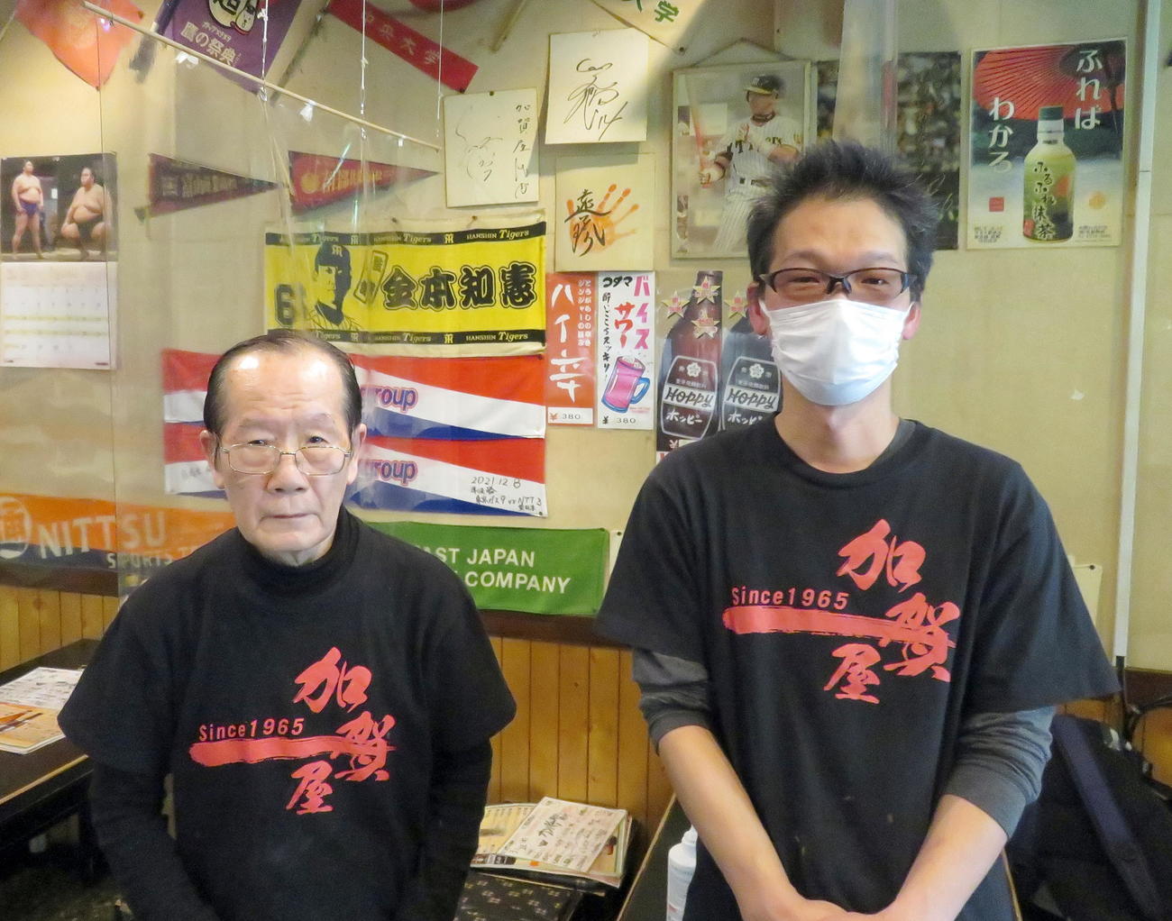 阪神優勝を願う「加賀屋水道橋店」の出井利昭社長（左）と巨人勝利も願う娘婿の鎌田和浩店長（撮影・鎌田直秀）