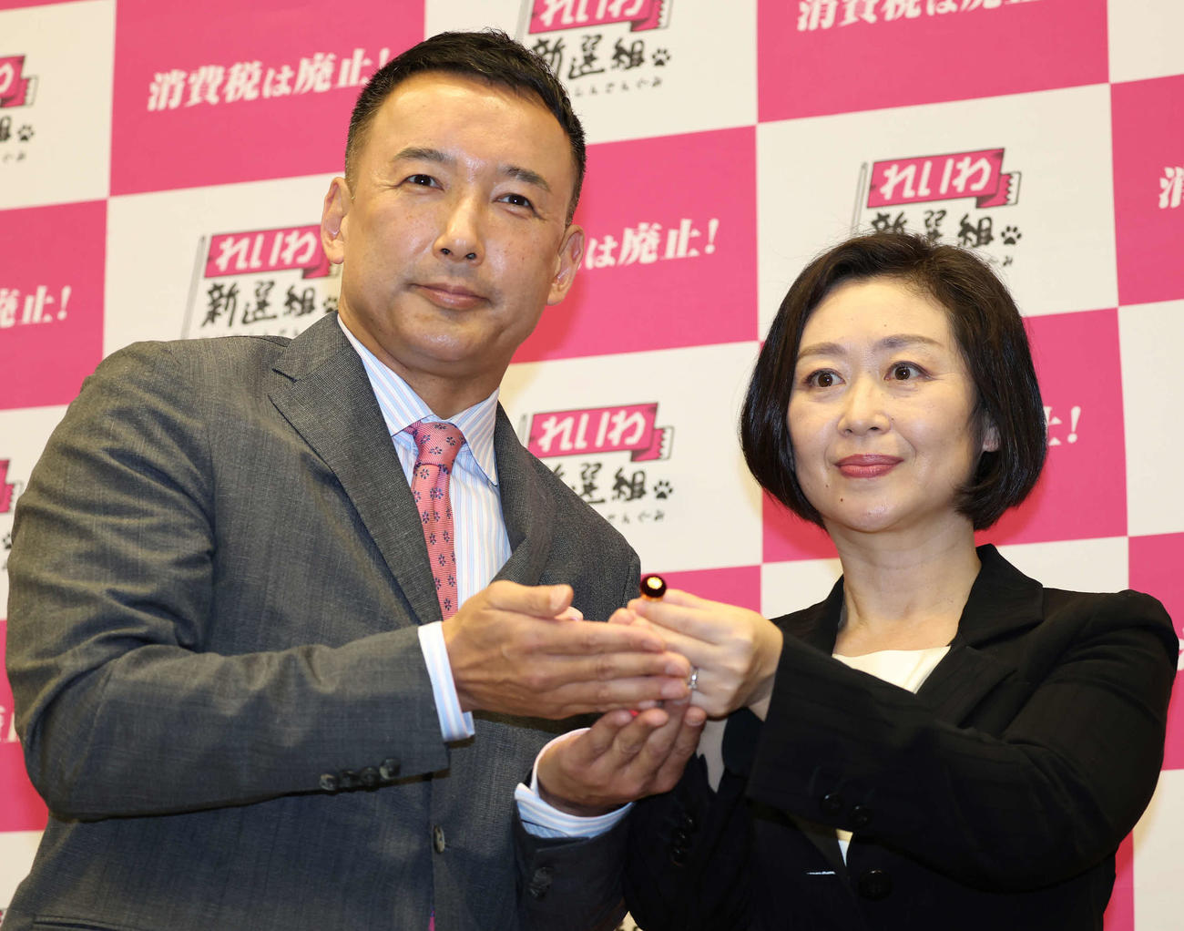 議員バッジがれいわ新選組代表の山本太郎氏（左）から櫛渕万里さんへ手渡された（撮影・丹羽敏通）