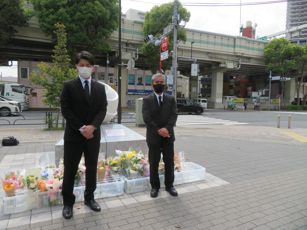 池袋暴走事故発生から3年を迎え、事故現場を背に慰霊碑に献花を終えた松永拓也さん（左）と義父の上原義教さん（撮影・村上幸将）