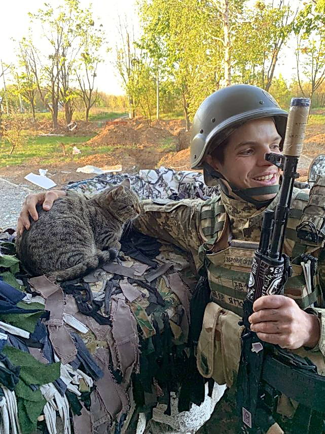 自動小銃を持ちながらネコをなでるイゴールさん（佐々木清志さん提供）