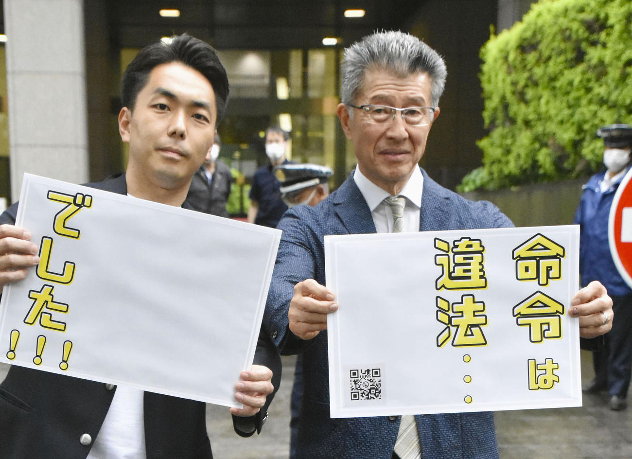 判決後、東京地裁前でボードを掲げるグローバルダイニングの長谷川耕造社長（右）ら（共同）