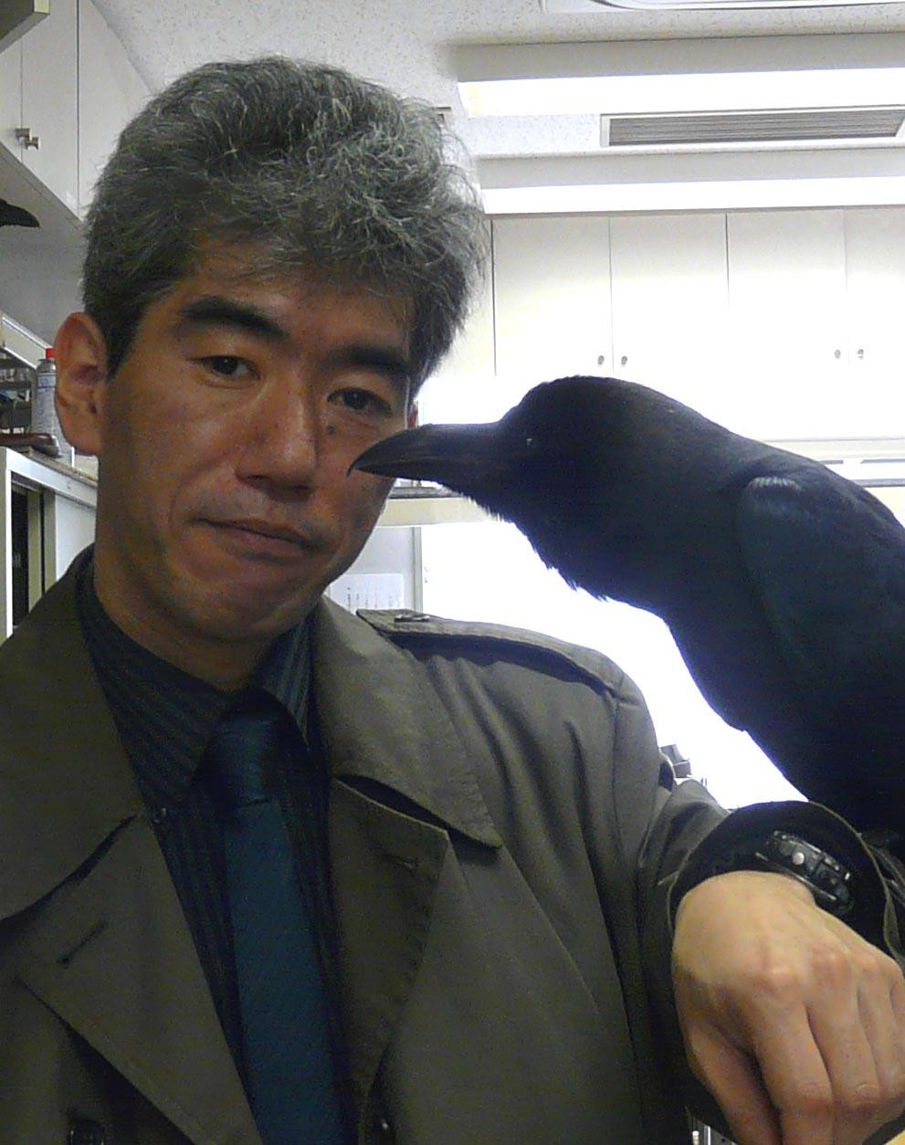 カラスを腕に乗せる東大総合研究博物館特任准教授の松原始さん