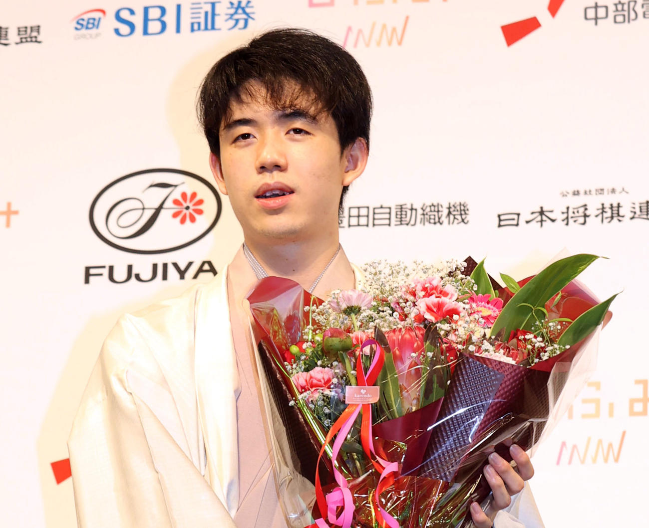 叡王戦初防衛を果たし、花束を手に記念撮影する藤井叡王（撮影・狩俣裕三）