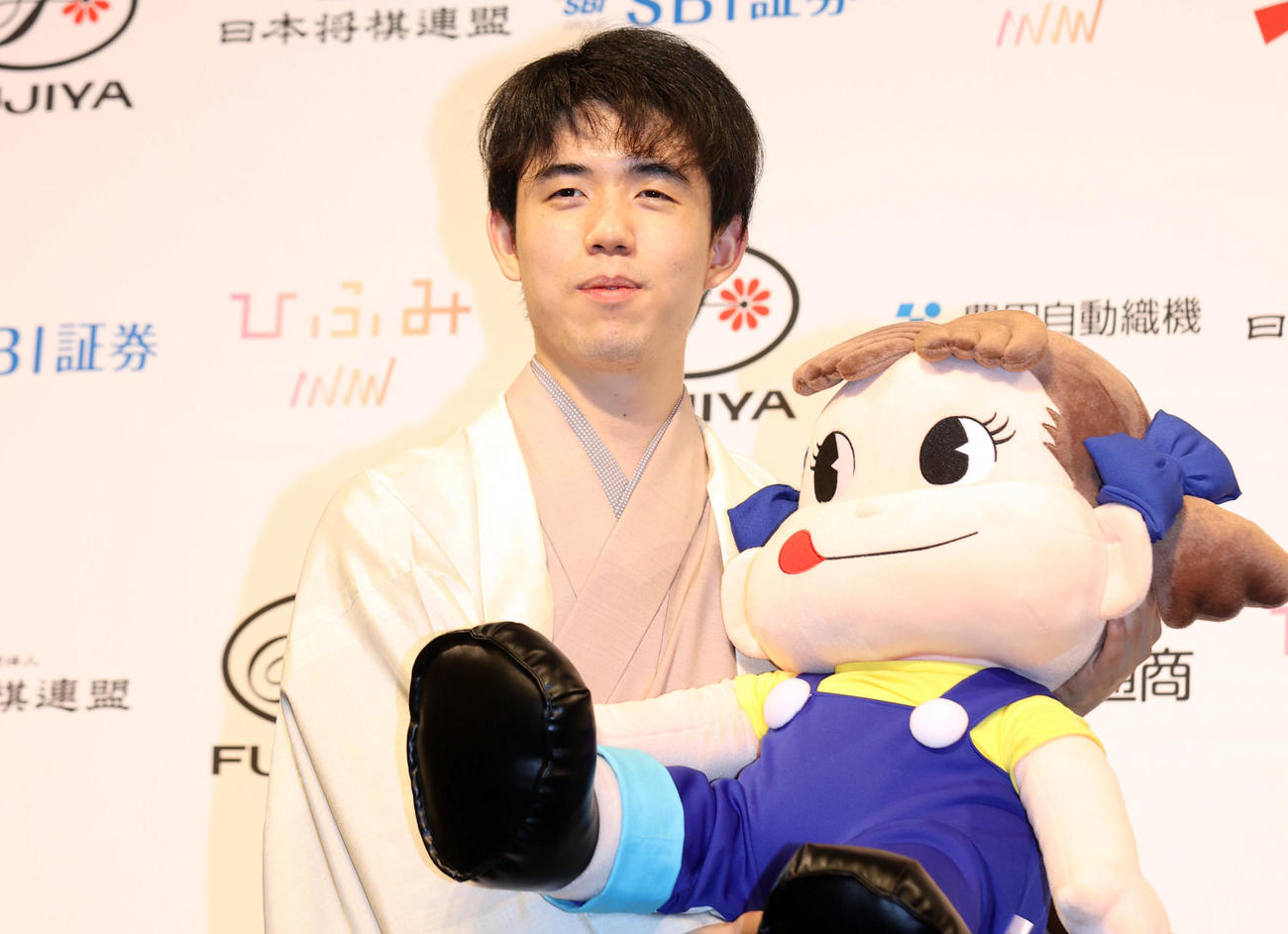 叡王戦初防衛を果たし、主催である不二家のペコちゃんのぬいぐるみを抱き、記念撮影する藤井叡王（撮影・狩俣裕三）