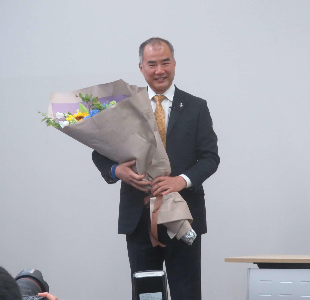 野口聡一宇宙飛行士が花束を手に笑顔で退職会見を締めくくった（撮影・大上悟）