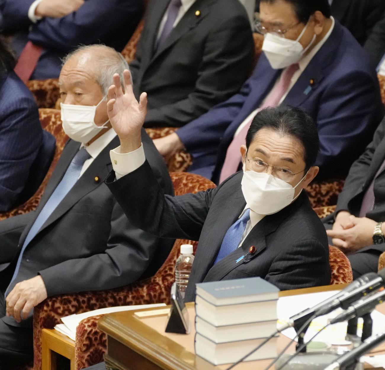 衆院予算委で答弁のため挙手する岸田首相（共同）