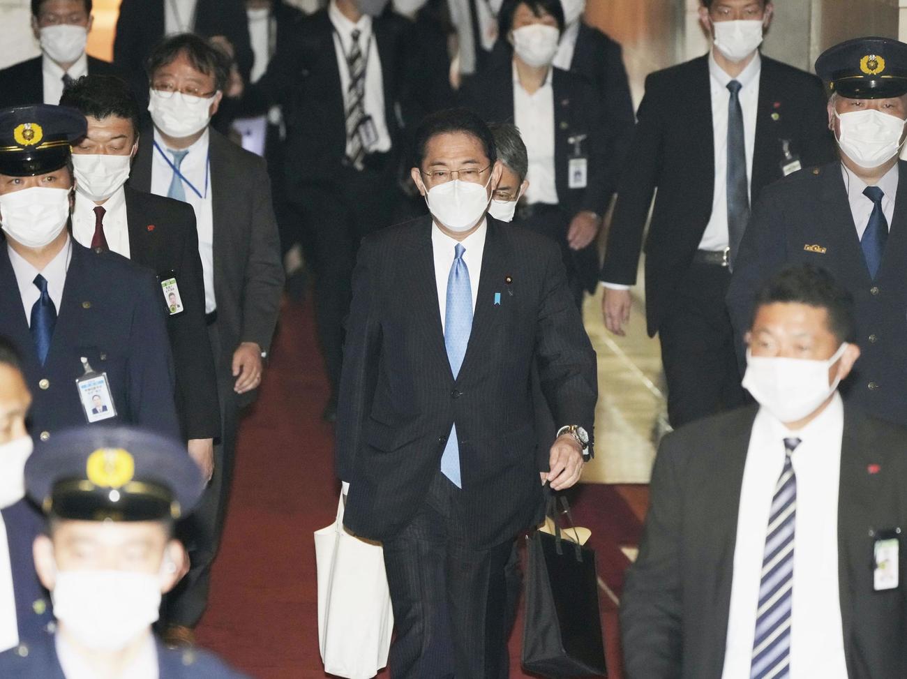 衆院予算委に向かう岸田首相（中央）（共同）