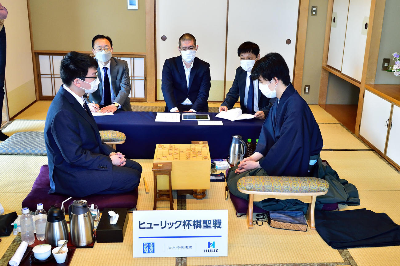 第93期ヒューリック杯棋聖戦5番勝負第1局、立会人から千日手の成立を告げられる藤井聡太棋聖（右）、永瀬拓矢王座（日本将棋連盟提供）