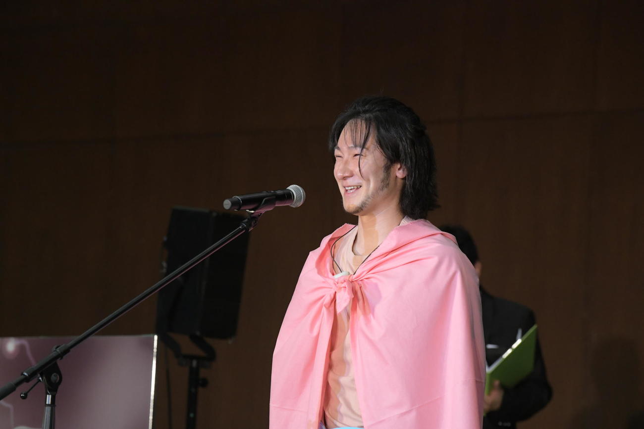 マイクの前で笑顔を見せる吉田昌弘さん（鳥取県提供）