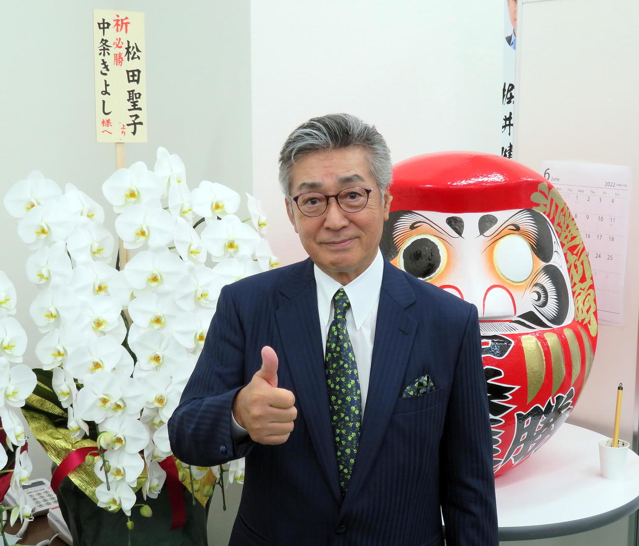 だるまや松田聖子から贈られた花の前で必勝を誓う中条きよし氏（撮影・鎌田直秀）