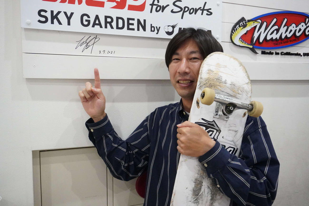 堀米雄斗のサインの前で笑顔を見せる境基州さん（撮影・沢田直人）