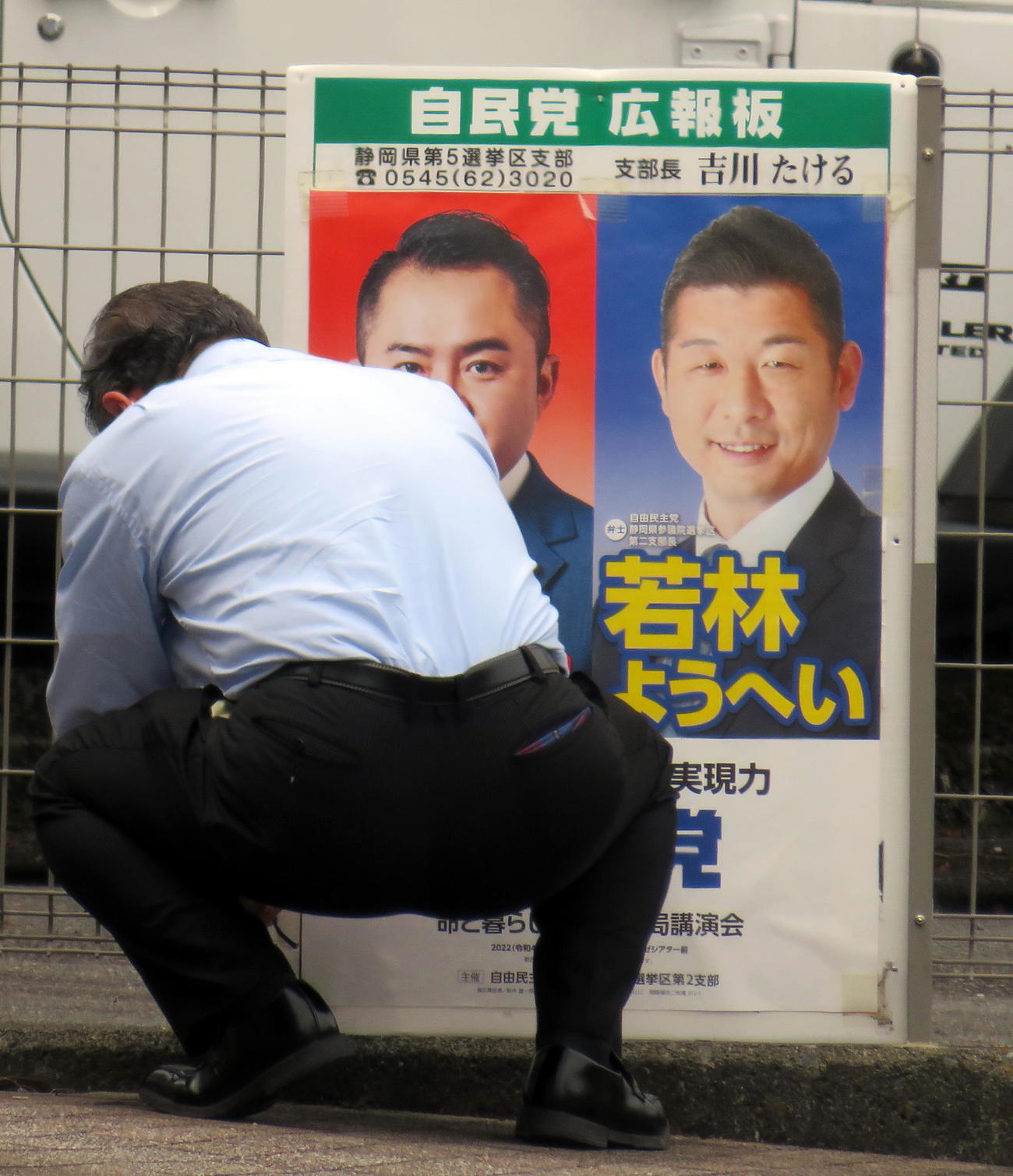 今夏の参院選自民党公認候補者の若林洋平氏（右）と吉川赳議員を2人並べた応援ポスターの撤去作業を行う吉川議員事務所関係者（撮影・鎌田直秀）