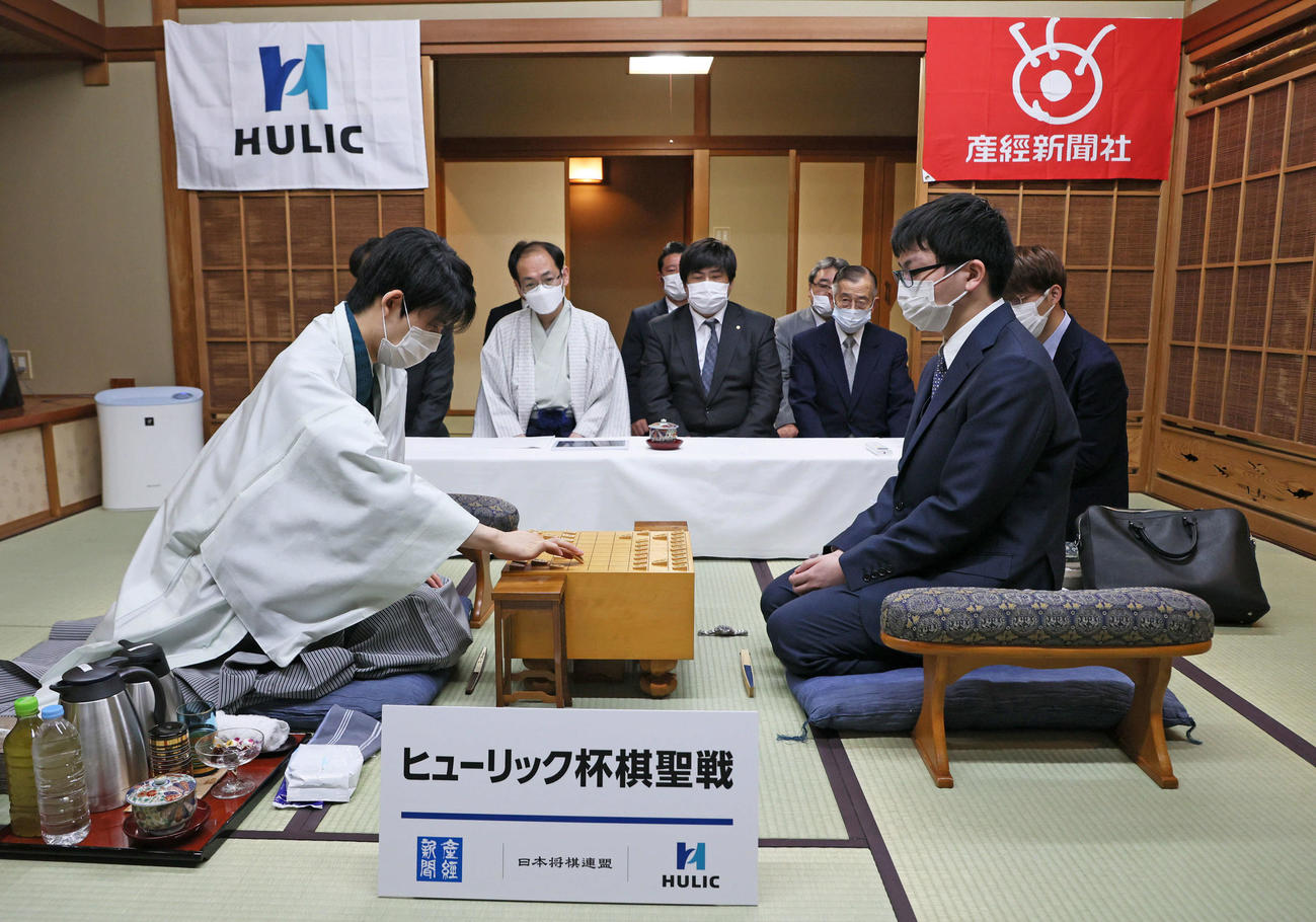 「第93期ヒューリック杯棋聖戦五番勝負」の第2局で2手目を指す藤井聡太棋聖（左）と永瀬拓矢王座（代表撮影）