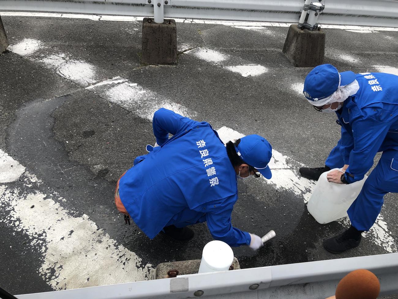 午後5時すぎに規制が解除され、血痕を洗い流す捜査員（撮影・益子浩一）